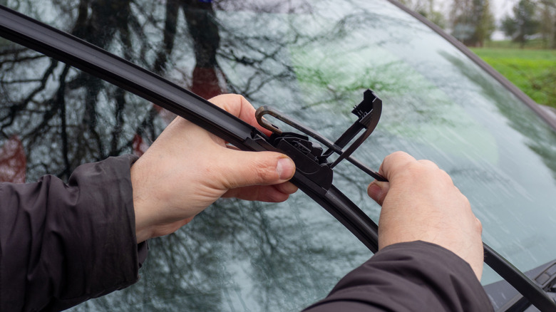 Man replacing wiper blade on car