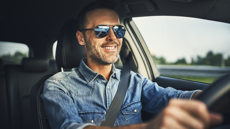 Man wearing sunglasses while driving