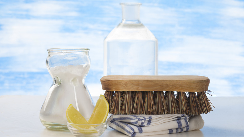 Vinegar and cleaning tools on table