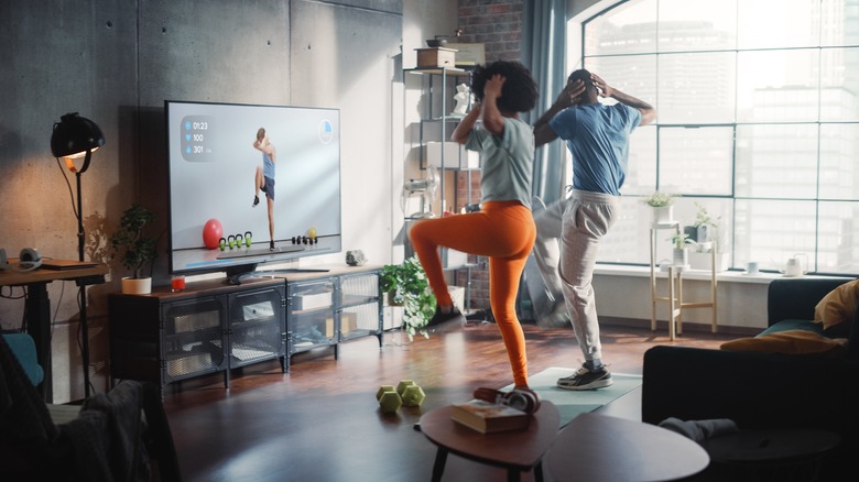 Man and woman doing workout on TV