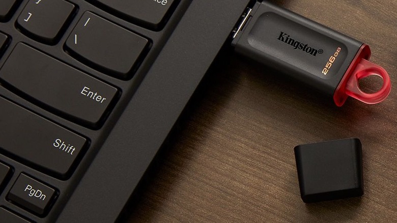 A Kingston USB drive plugged into a black laptop.