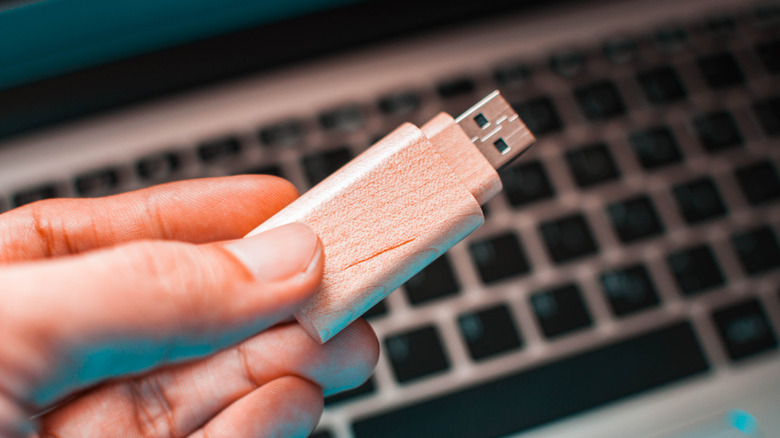 Close up of a hand holding USB flash drive.