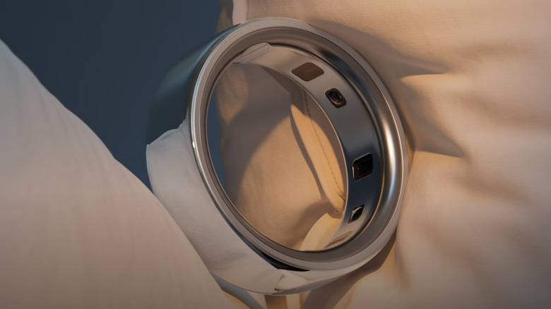 Silver Oura Ring 4 on a pillow with a focus on its sensors