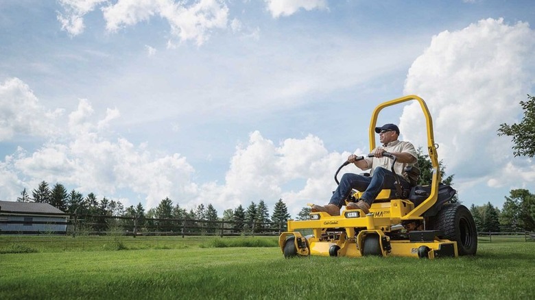 Man on Cub Cadet zero-turn riding lawn mower mowing the lawn