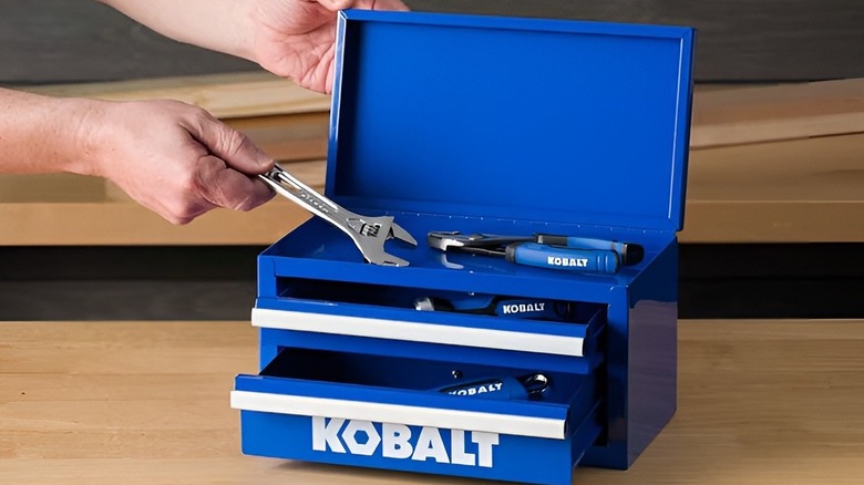 Hands putting wrench into blue Kobalt drawer tool box