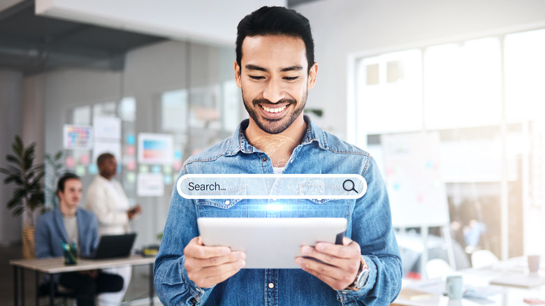 Man holding tablet with search interface overlay
