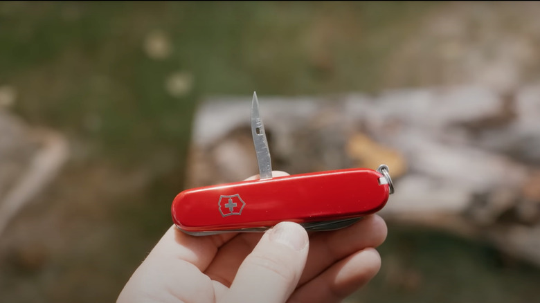 Person showing Swiss Army Knife sewing awl on display