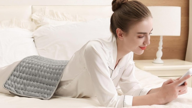 woman lying down with heating pad