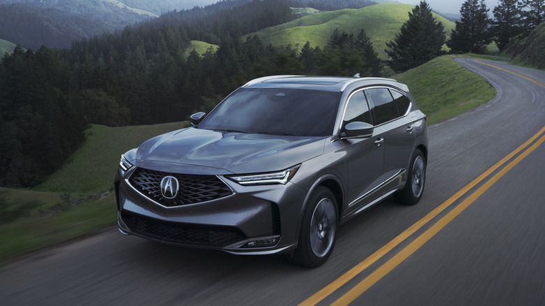 2025 Acura MDX driving up a mountain road