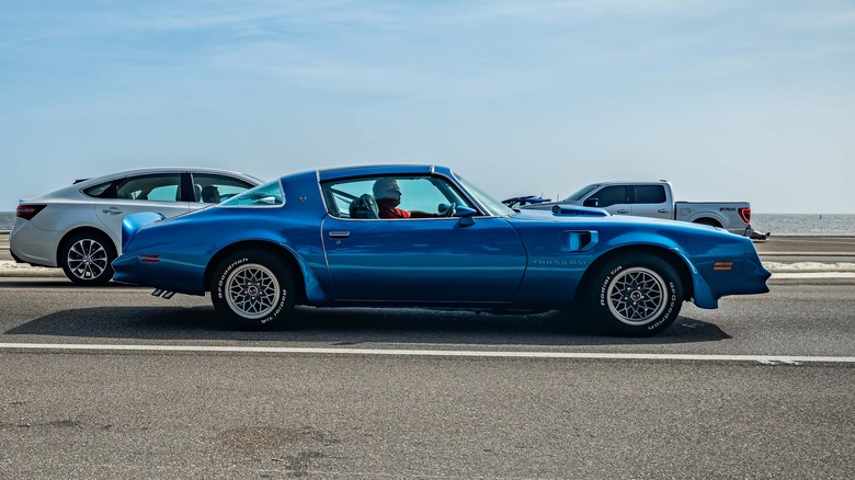 Pontiac Firebird driving down a road