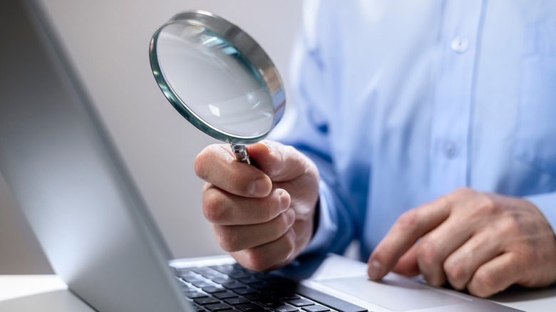 Magnifying glass in front of laptop screen