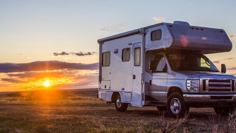 Camper parked on flat land with sunset