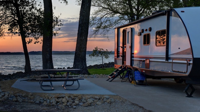 A RV parked on a lake at sunset