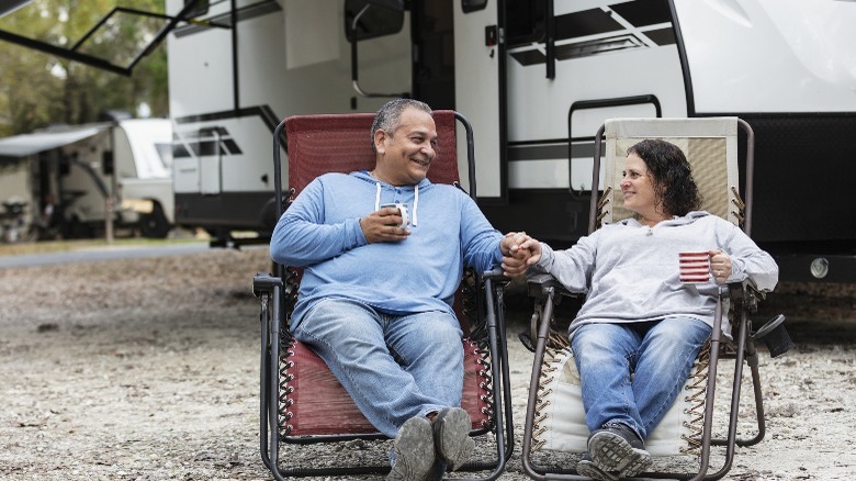 Couple sitting in front of an RV