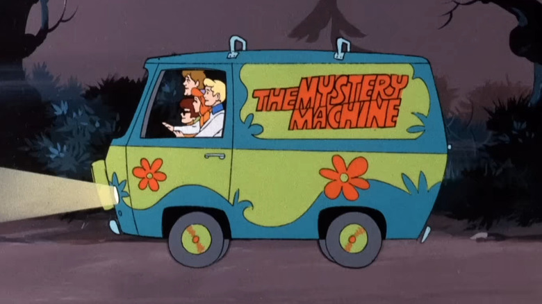 The Mystery Machine driving down forest path