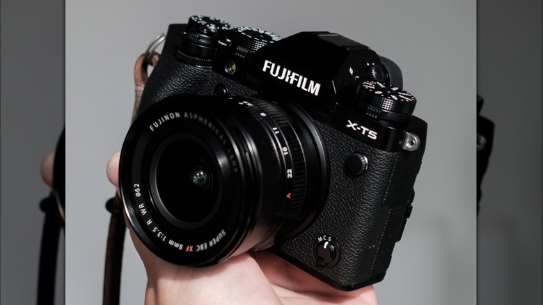 A Fujifilm X-T5 camera held in the hand