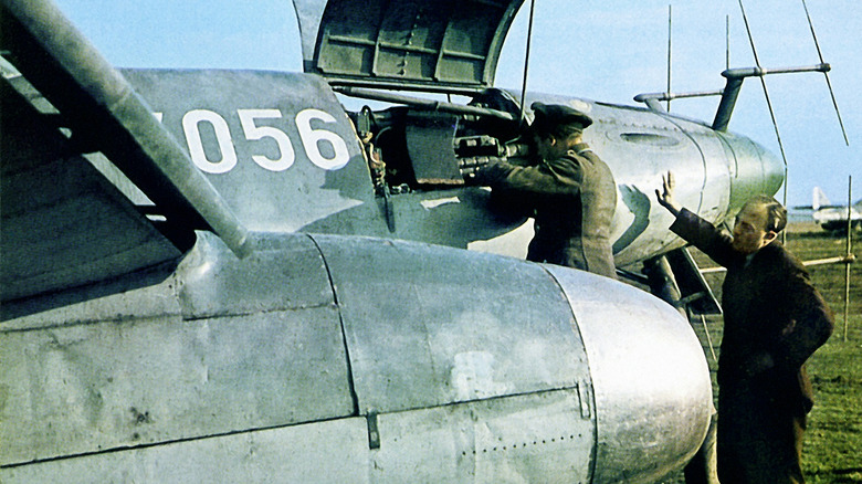 People working on an Me 262 with its engeine compartment open.