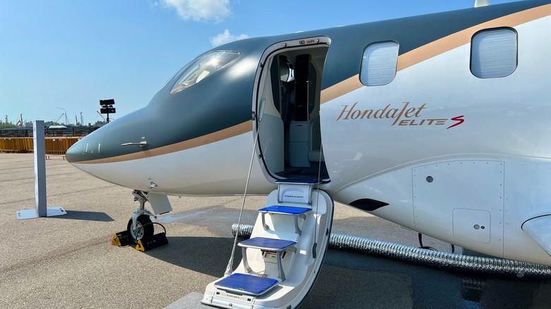 A HondaJet Elite S parked at an airport with its stairway open.