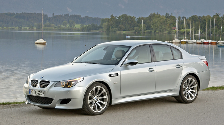 Silver BMW M5 parked near a lakeside