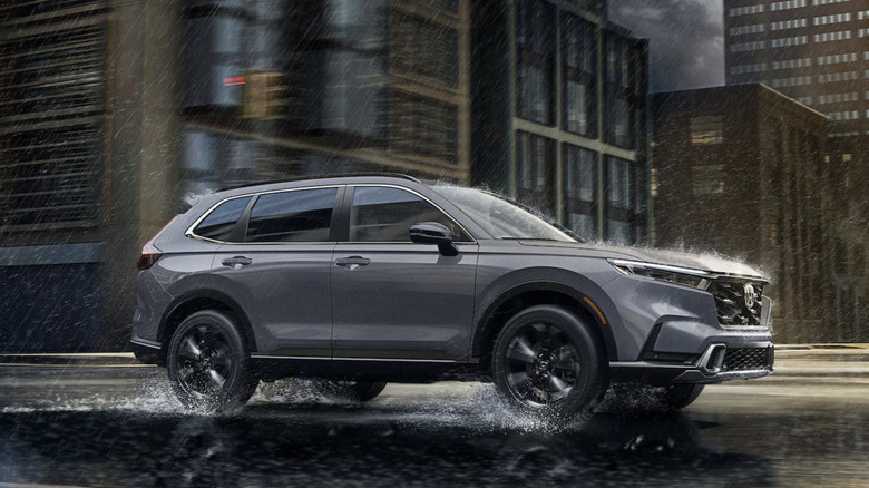 Gray 2025 Honda CR-V driving on a city street in the rain