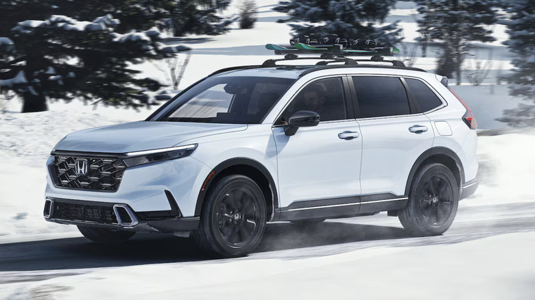 White 2025 Honda CR-V driving on a snowy road