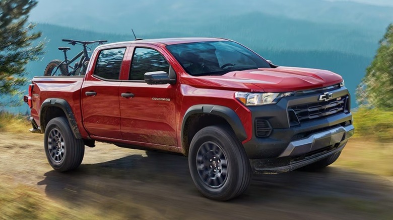 red 2025 Chevrolet Colorado driving on a mountain road.