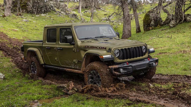 Army green Jeep Gladiator on muddy trail