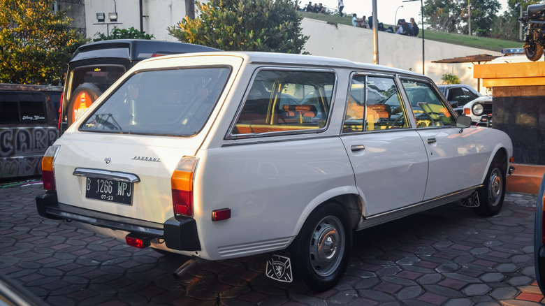 A white Peugeot 504 Estate parked outside a public establishment