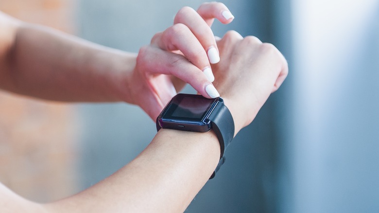 tapping Fitbit on wrist