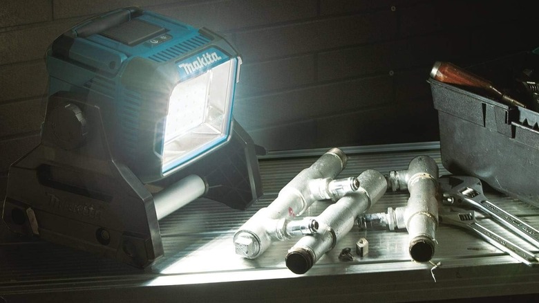 Makita tripod light shining on metal piping