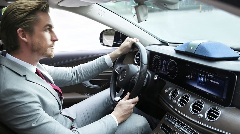 Person driving with Blue Luftrum Car Air Purifier on their dashboard