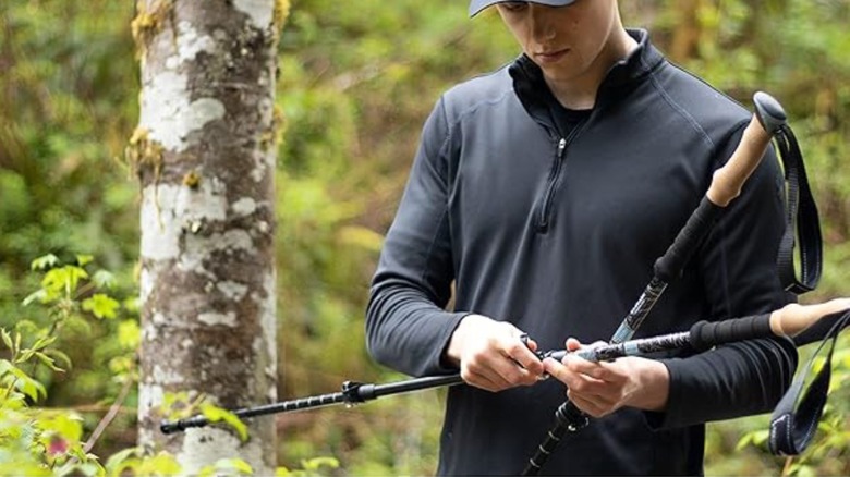 Person setting up trekking poles for a hike