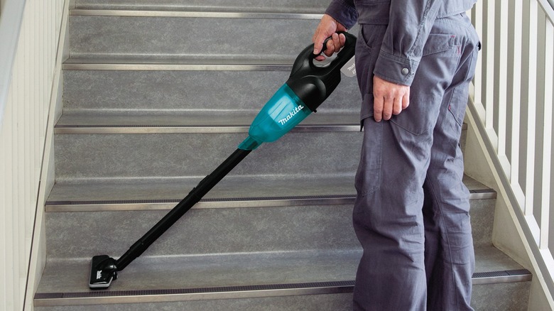 Using the Makita cordless stick vacuum cleaner on stairs.