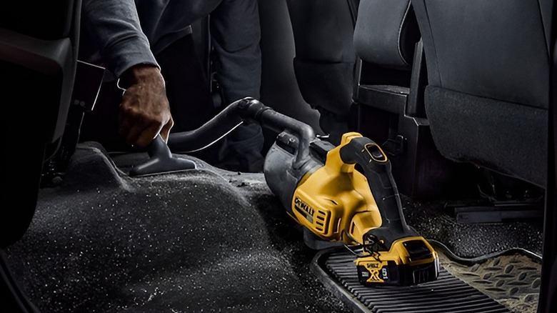 Vacuuming car floor with DeWalt vacuum