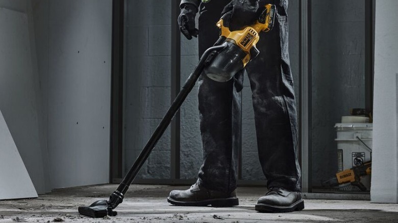 Person using 20V Cordless Dry Hand Vacuum to clean floor