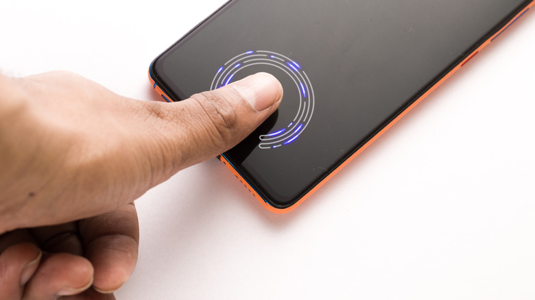 Person using thumb to scan fingerprint on Android phone