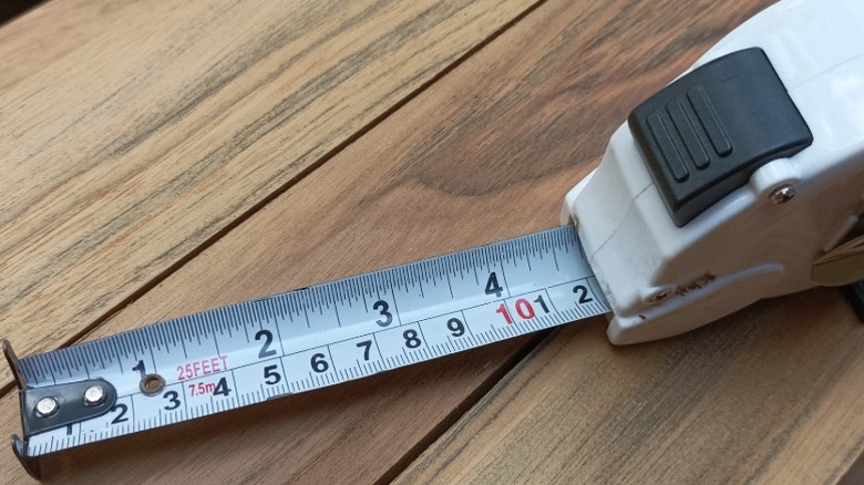 A white tape measure on a piece of wood