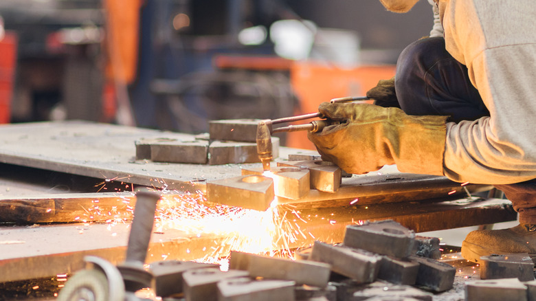 man cutting metal with acetylene torch