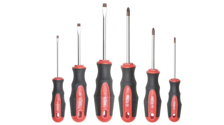 Six red and black handled screwdrivers against white background