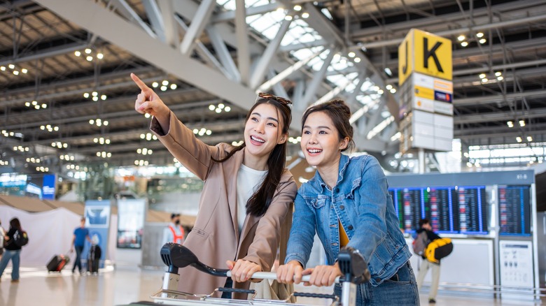 women pointing inside airport