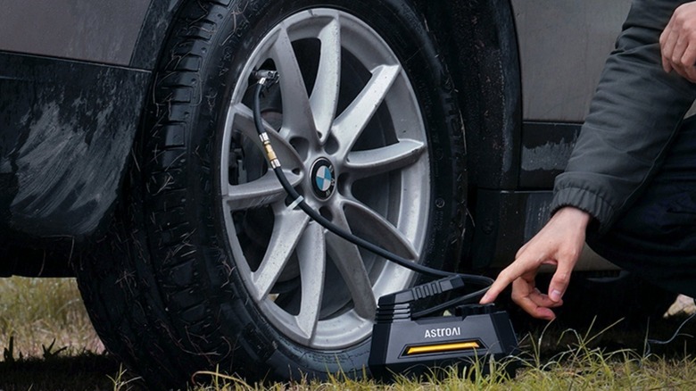 Person putting air in their car's tire