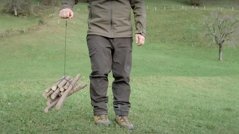 Man carrying firewood with Swiss Army knife