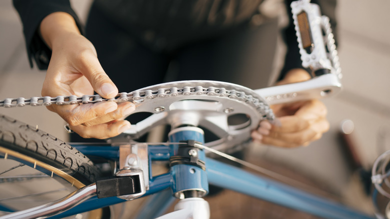 Person working on a bike chain