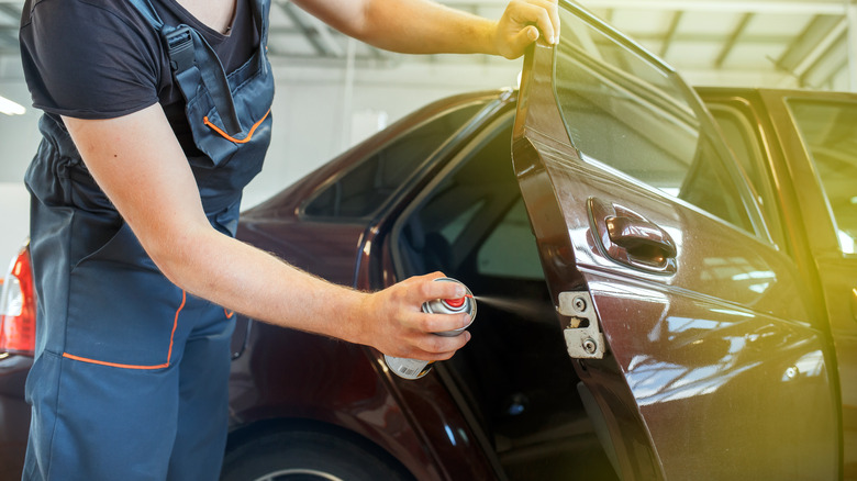 Spraying lube on door latch