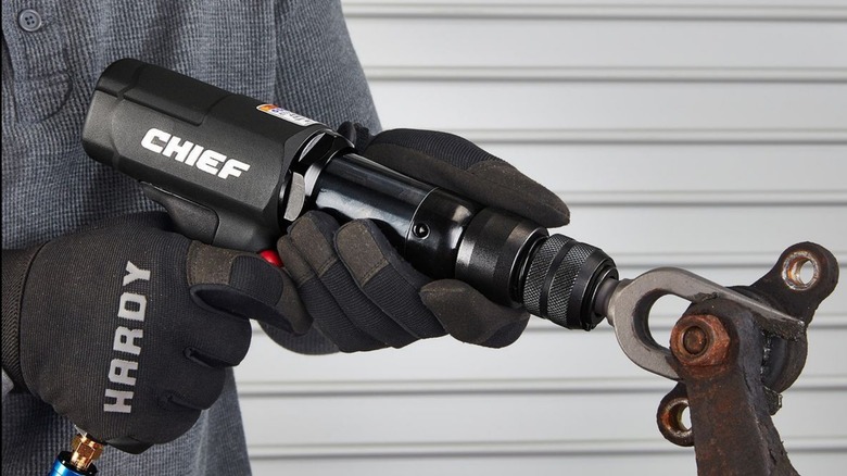 A person using a CHIEF air hammer to separate a ball joint