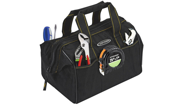 A tool bag with tools in the pockets with a white background