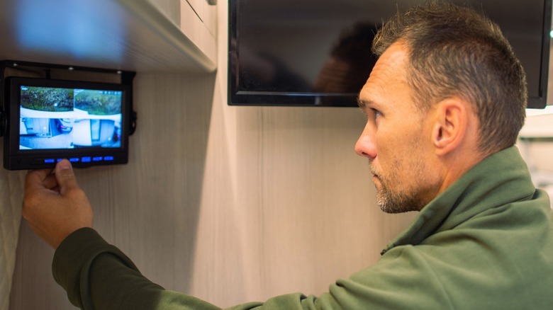 Man monitoring RV security cameras from inside an RV