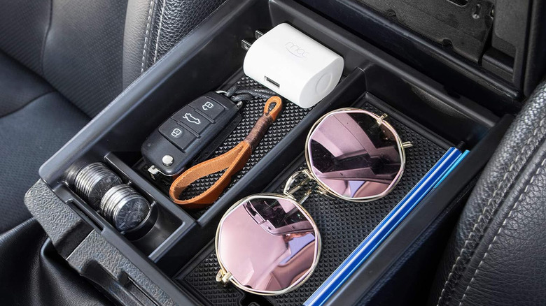 Toyota Tacoma console tray with keys, charger, coins, and sunglasses