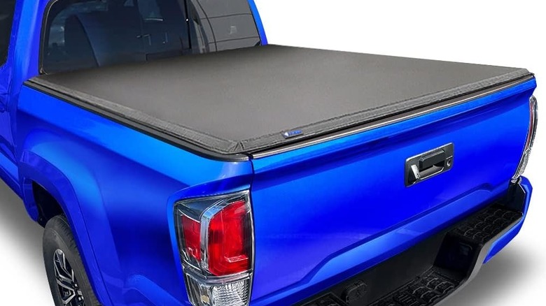 Black soft tonneau cover on bed of blue Toyota Tacoma pickup