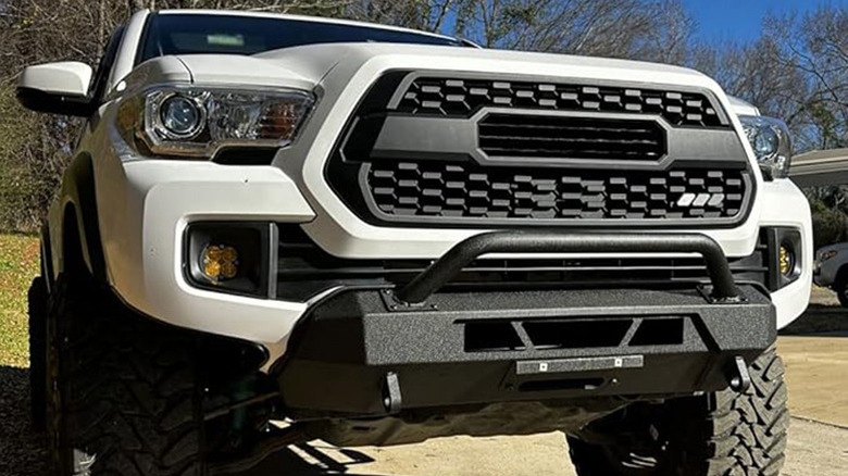 Winch bumper mounted on white Toyota Tacoma pickup truck